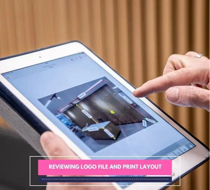 Person reviewing logo file and print layout on tablet during window sticker survey