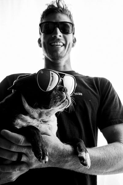 Blenders Entourage athlete Nathan Florence holds a dog donning Blenders polarized sunglasses