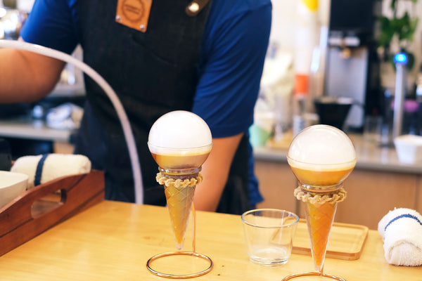 Two perfectly-crafted "Tropi-Cone" cocktails await presentation in practice.