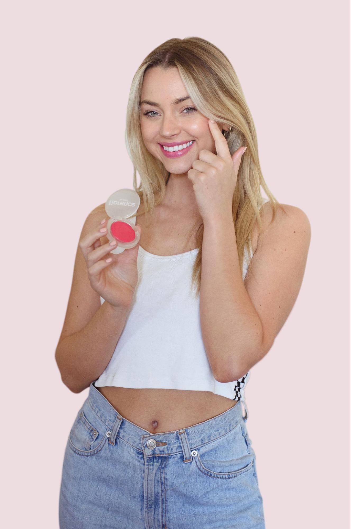 Girl putting on blush on her cheeks