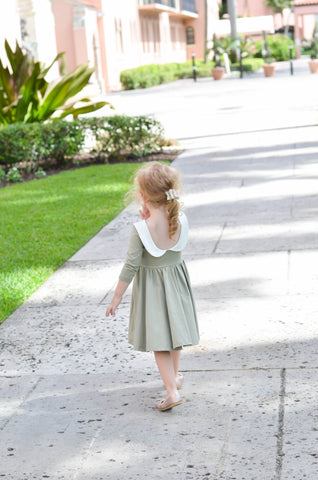 young blonde child walking in an art deco area in an adorable light green dress