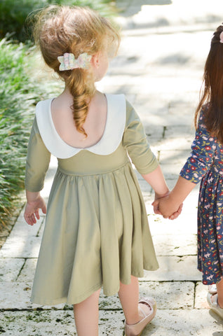 little girl in green dress with peter pan collar walking and holding hands with a friend