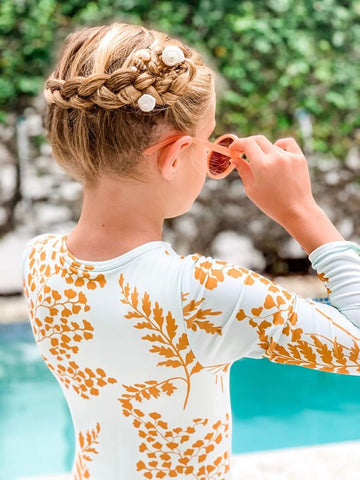 girl by pool with braided hair styles and shell accessories