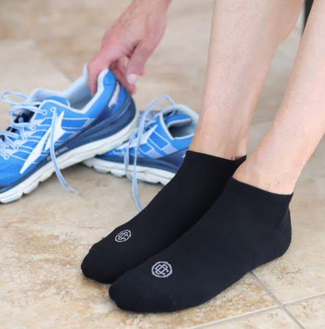 Person with doctor's choice no-show socks putting on sneakers
