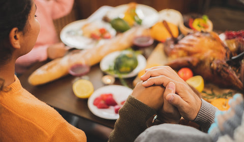 family holding hands and giving thanks on Thanksgiving
