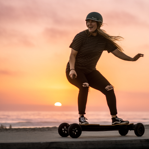 girl riding an electric skateboard during the sunset