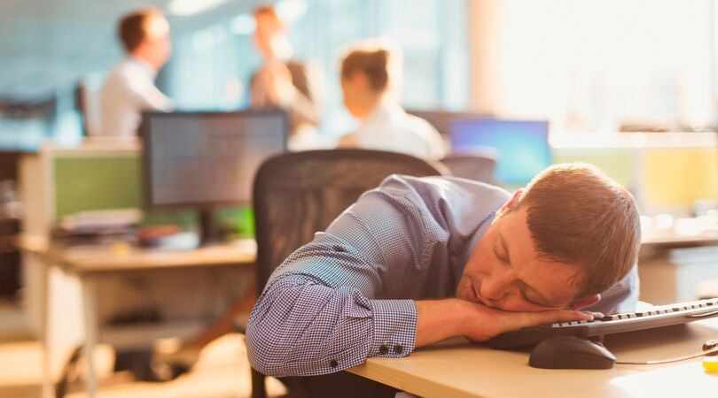 fatigue - man sleeping on his desk at work