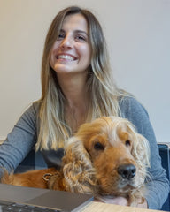 Laughing woman cuddling a happy English Cocker Spaniel dog