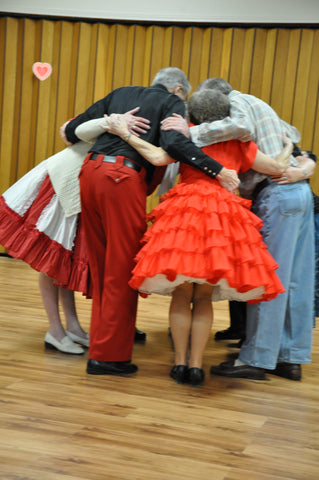 senior citizens square dance hug