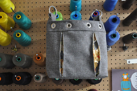tweed grey bag with pleats on a wall of thread