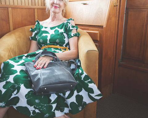 woman seated in chair in party dress with grey purse