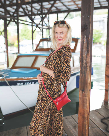 woman in leopard dress with waterproof red bag on a boat dock in seattle