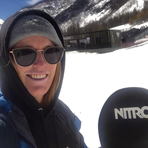 woman at the snow wearing sunglasses with a snowboard