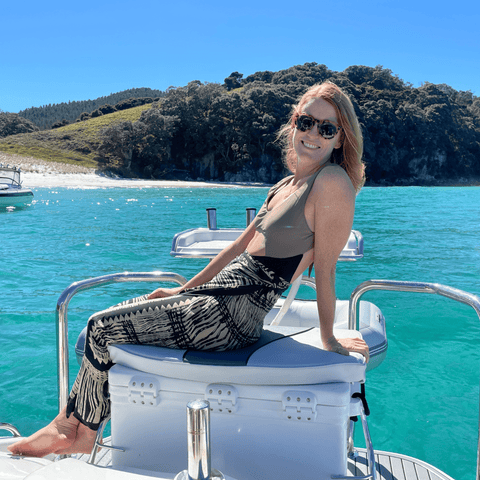 oman with red hair in a sarong sitting on the back of a boat