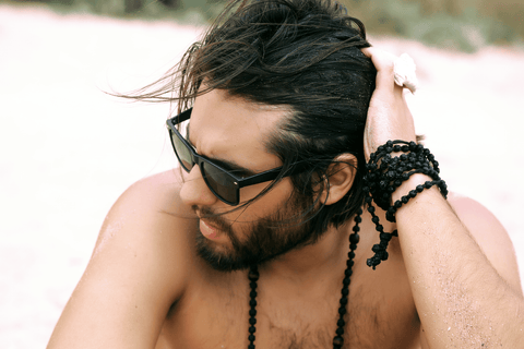 Man holding hair at the beach