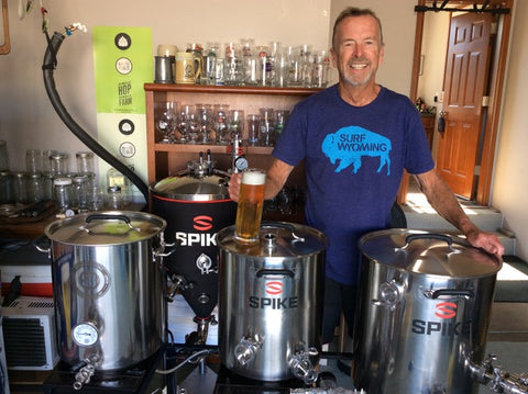 A man (Duane Teachout of West Wind Brewery) standing in front of Spike Brewing equipment, homebrewing a Kolsch beer recipe.