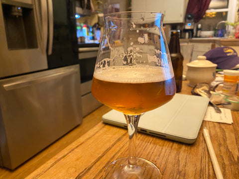 Glass of Tripel beer sitting on a counter