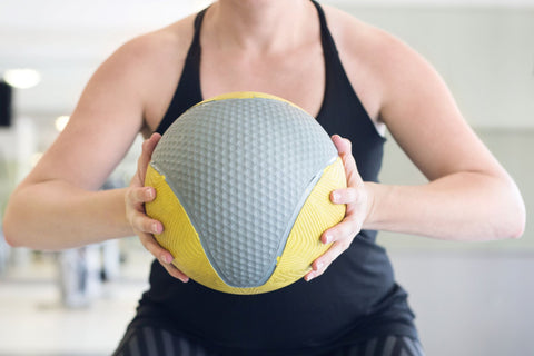 Woman using a medicine ball in her home gym workout