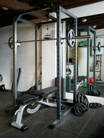 Home gym with rack, adjustable bench, weight plates, barbell, and more!