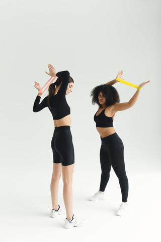 Two women using resistance bands in their home gym for a workout