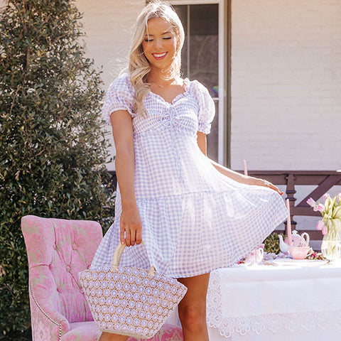 Believe us when we say this charming dress will look so sweet on you with its lightweight material, small purple and white gingham print, a smocked bodice with a center tie closure ruched detail, a flirty neckline, short puff sleeves with subtle ruffle trim, and a relaxed babydoll silhouette that falls into a straight mid-thigh length hemline!