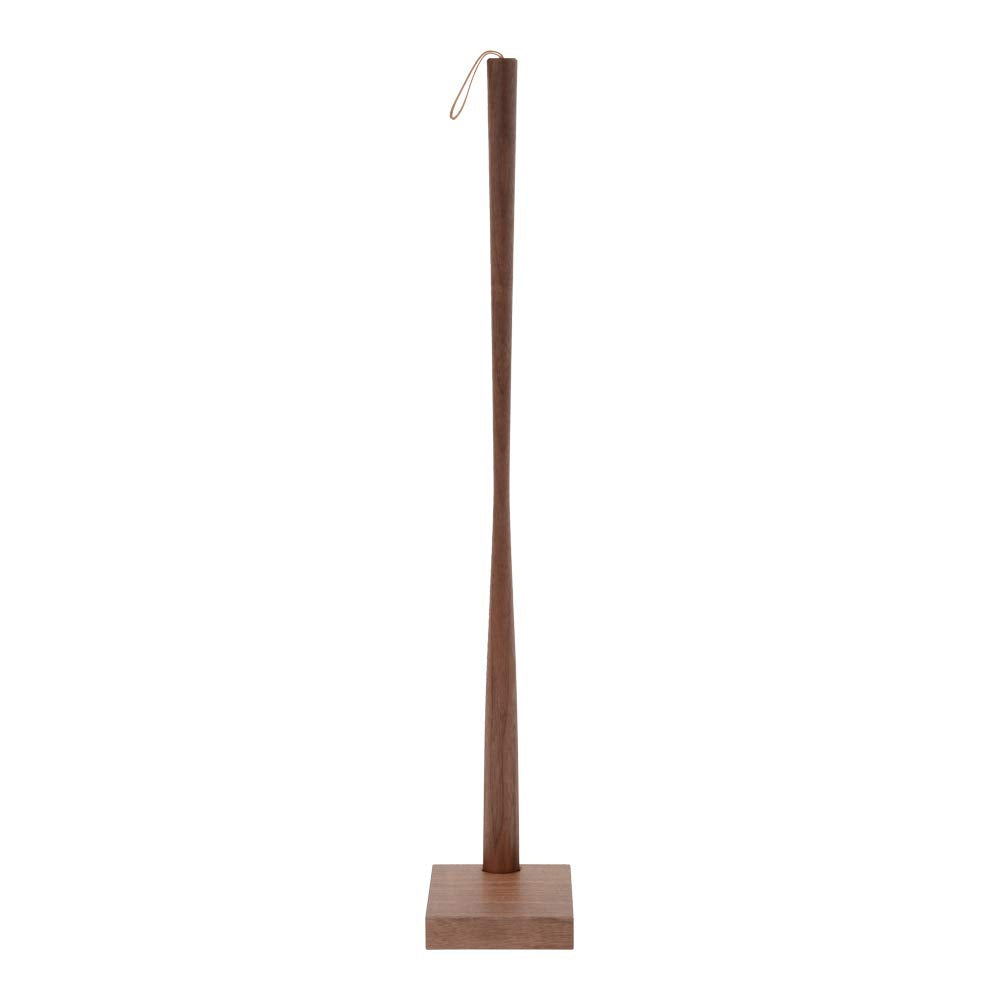 Long wooden shoe horn standing in its wooden base.