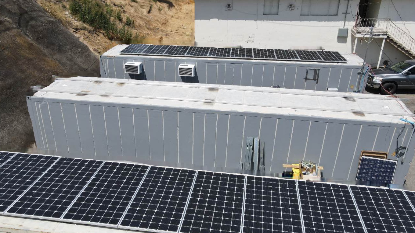 Storage units are lined up with solar panels on the roof. Inside each storage unit is pounds of food to be distributed to those in need.
