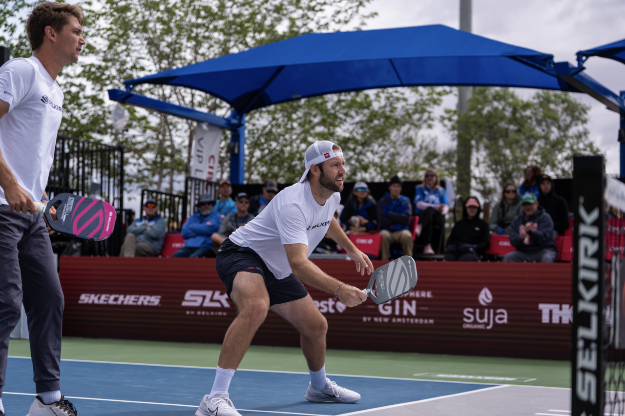 Professional pickleball players Collin Shick and Jack Sock are firmly positioned at the kitchen line, taking an offensive role on the court.