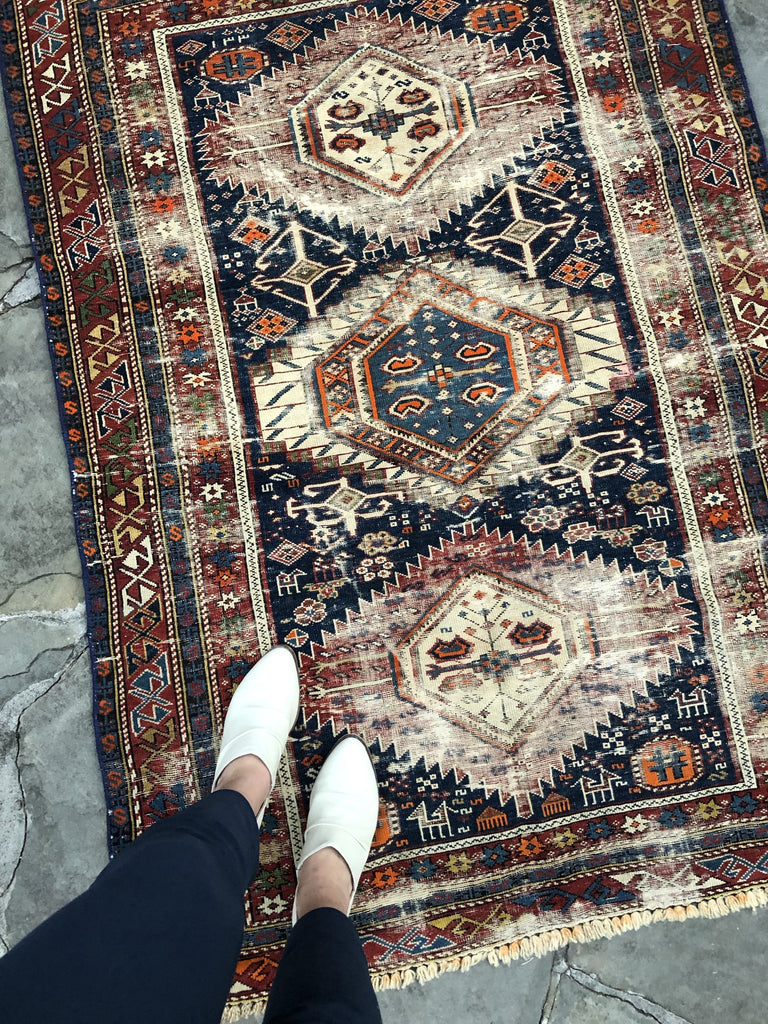 White shoes on an antique rug.