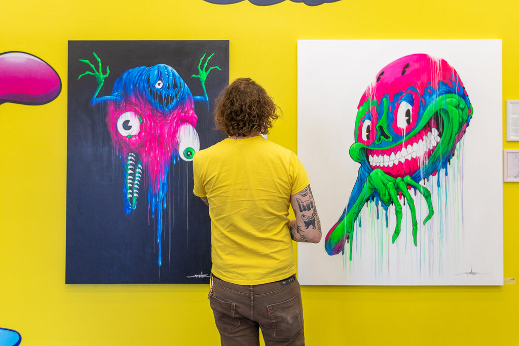 A gallery visitor viewing Alex Pardee artwork