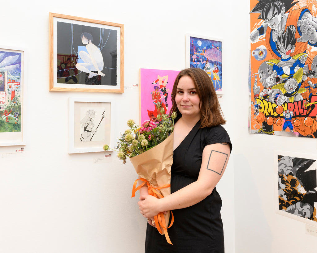 artist holding flowers at show opening 