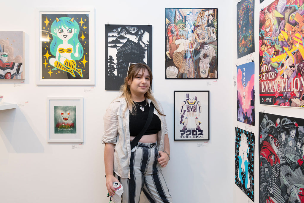 Artist Ellie Reis in front of their "Deathbucks" artwork for Anime in LA