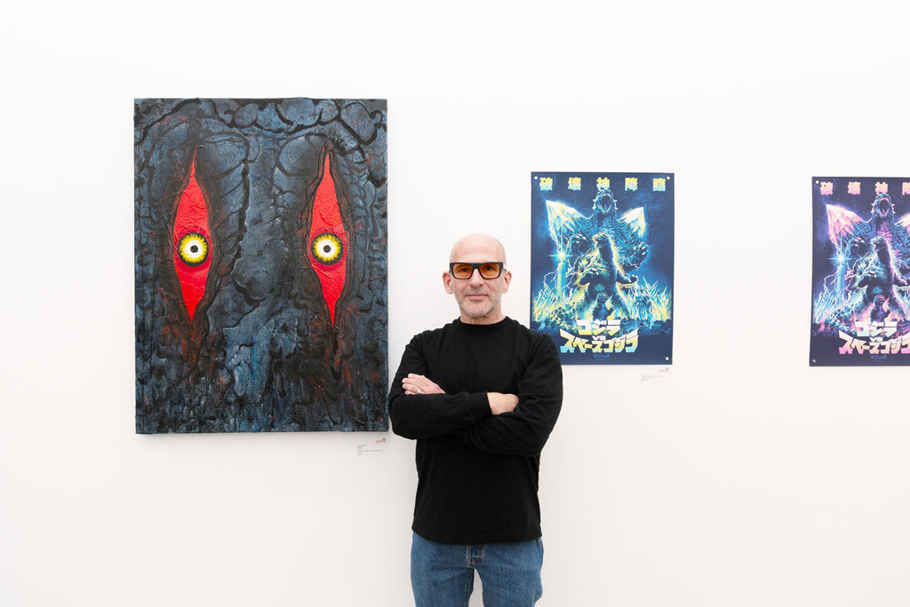 Artist Joey Feldman in front of his painting Hedorah at the opening reception of 70 Years of Godzilla