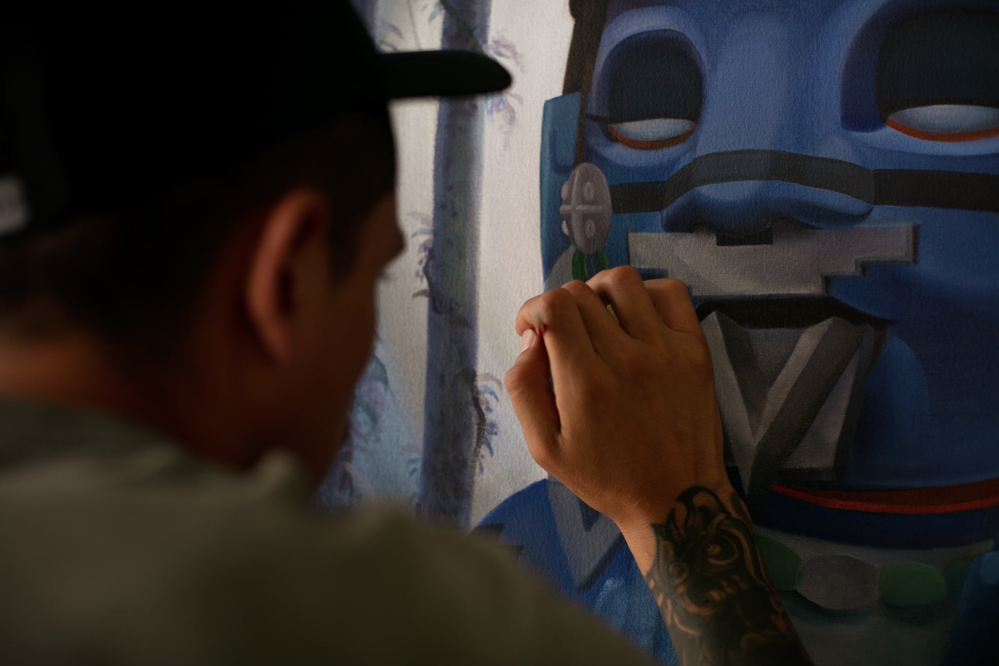 photo of artist pemex painting on a large canvas