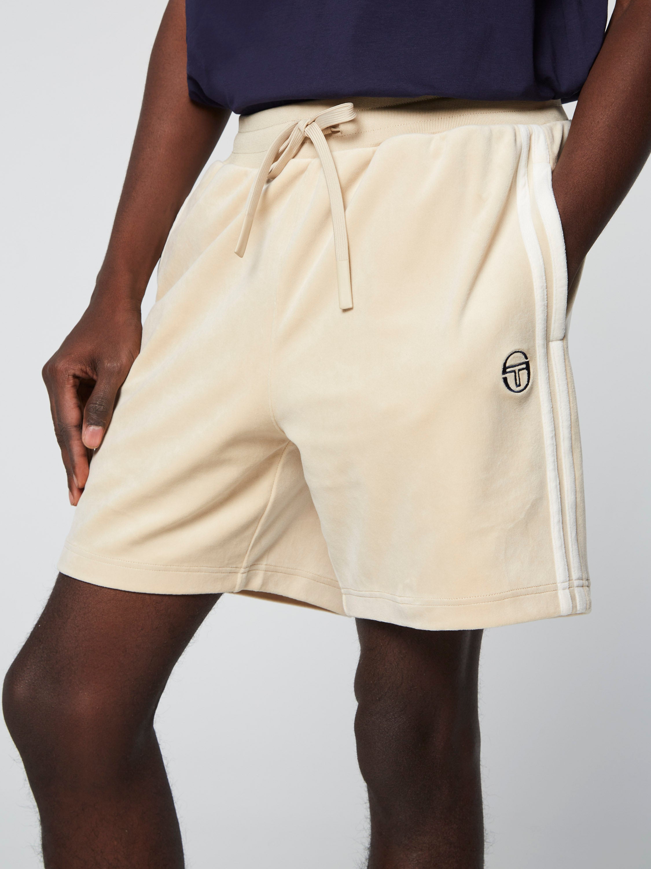 Cream velour shorts on a tall slender dark skin man