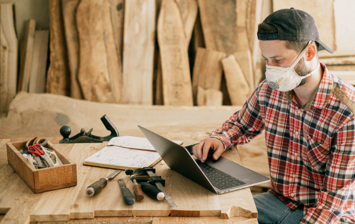 Man in his workhouse planning a DIY project with pine wood planks