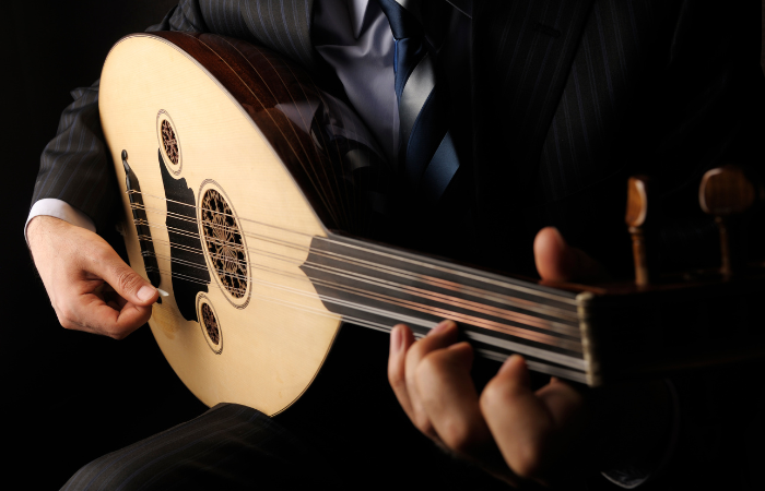 Person playing the Arabic Oud made from Walnut wood