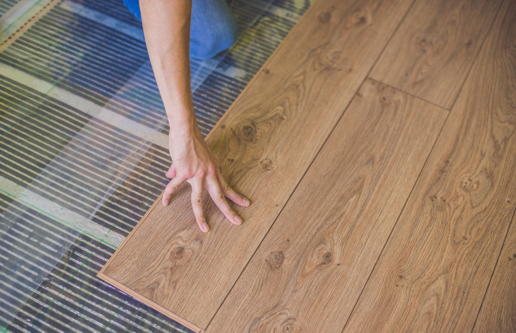 Person layering wood planks on the floor