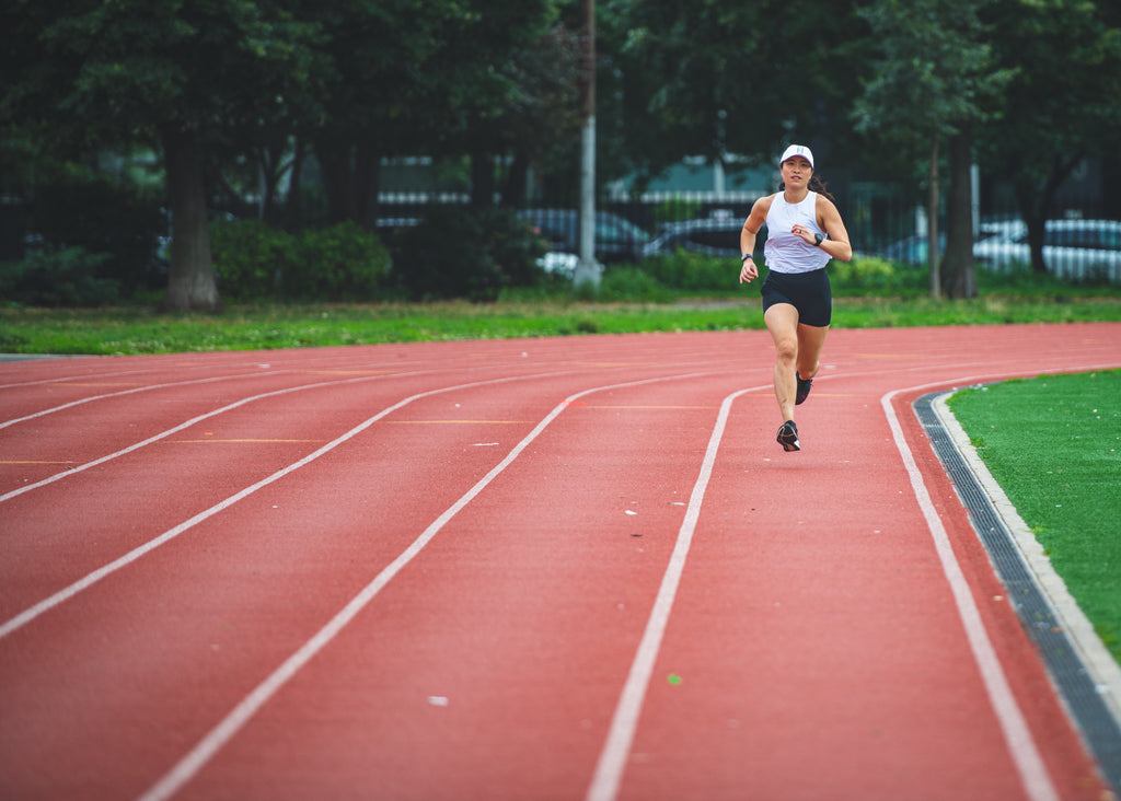 Female runner warming up on a track in preparation for a speed workout