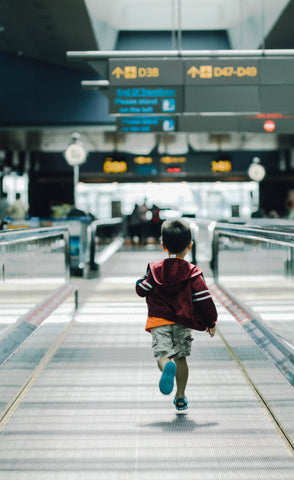 A small boy running in an airport