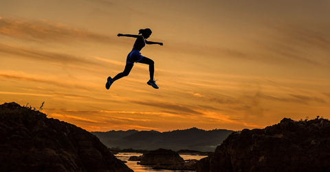 A woman jumping on rocks