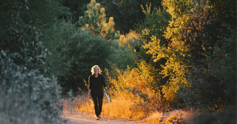A woman walking in the fall to absorb the sun and feel better during the shorter fall days.