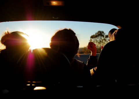 A group of people sitting in the back of a car