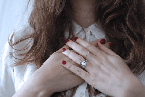A woman holding her hands to her heart
