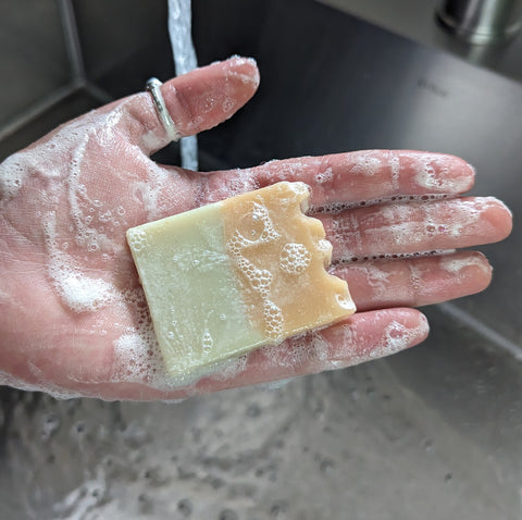 This person is lathering their hands with Olive Oil soap.