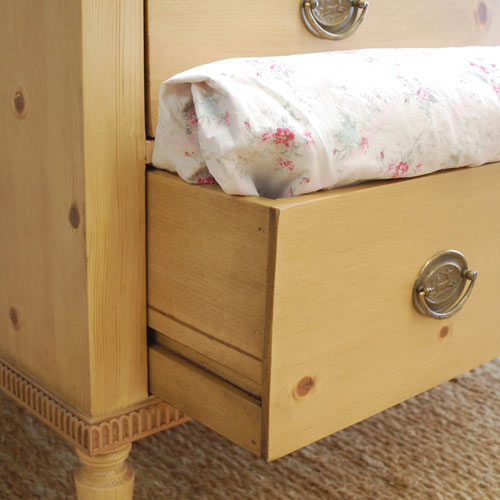 close up of bottom drawer of madeline chest with linens 