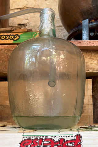 The lavender essence hydrosol pours from the alembic to the demijohn