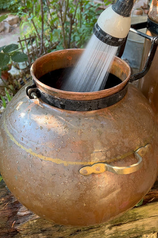 Filling the boiler of the alembic with water to distill lavender
