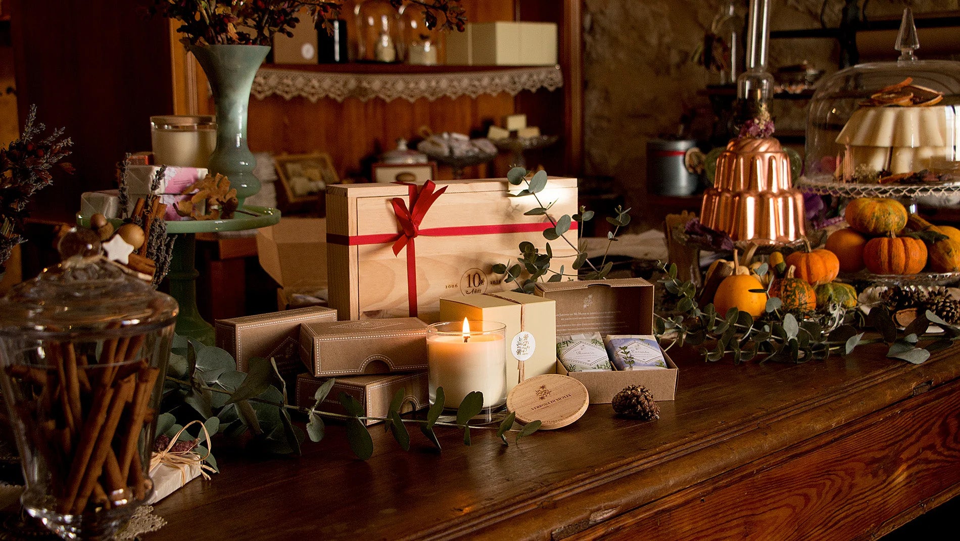 Cinnamon in a glass jar, soaps on a green plate, wooden boxes of soaps on a table