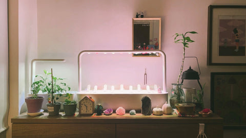 The Click & Grow Smart Garden 9 on a table surrounded by cozy lighting in a home.